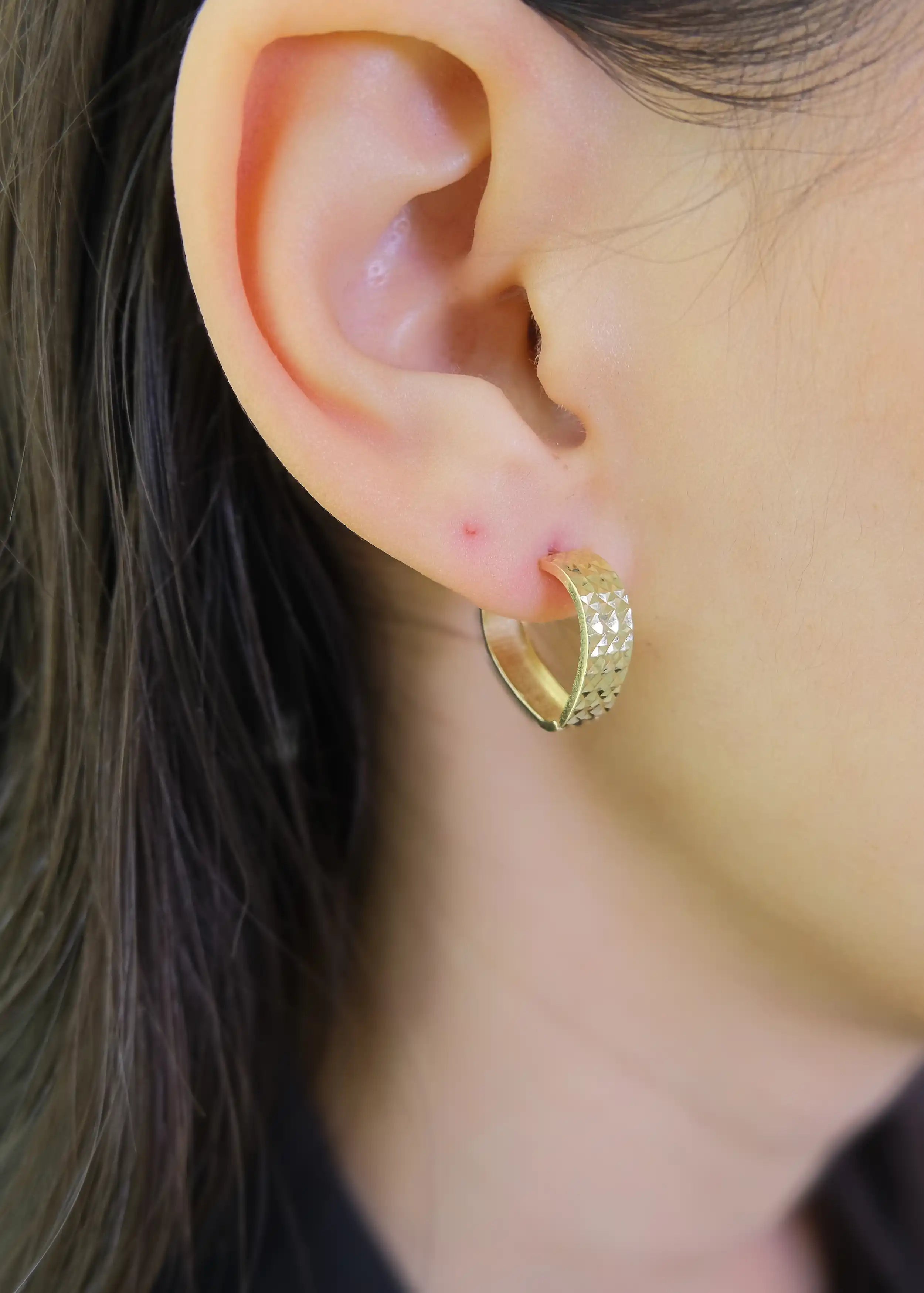 Eine Damme trägt Creolen Gold-Ohrringe in Herzform mit Muster aus 14 Karat Gelbgold mit Schnappverschluss – Minimalistisch, romantisch und klassisch