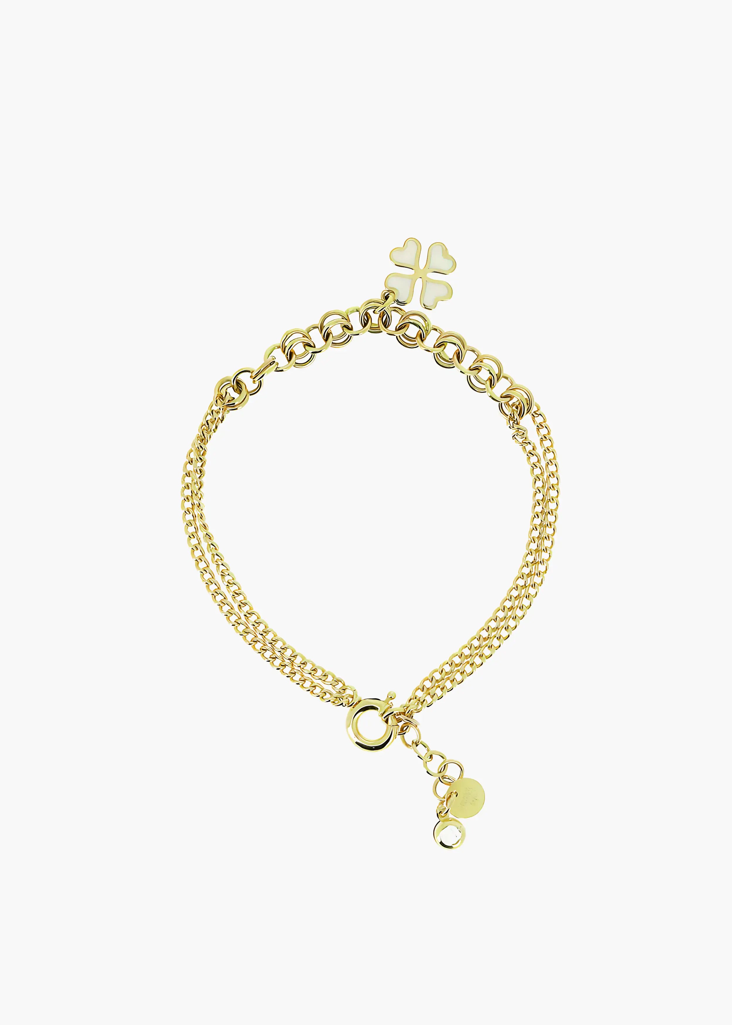 Goldenes Armband mit doppelter Gliederkette und einem vierblättrigen Kleeblatt-Anhänger aus weißen Herzchen, auf weißem Hintergrund. Die Kette hat einen Karabinerverschluss und eine Verlängerungskette mit einem runden Anhänger