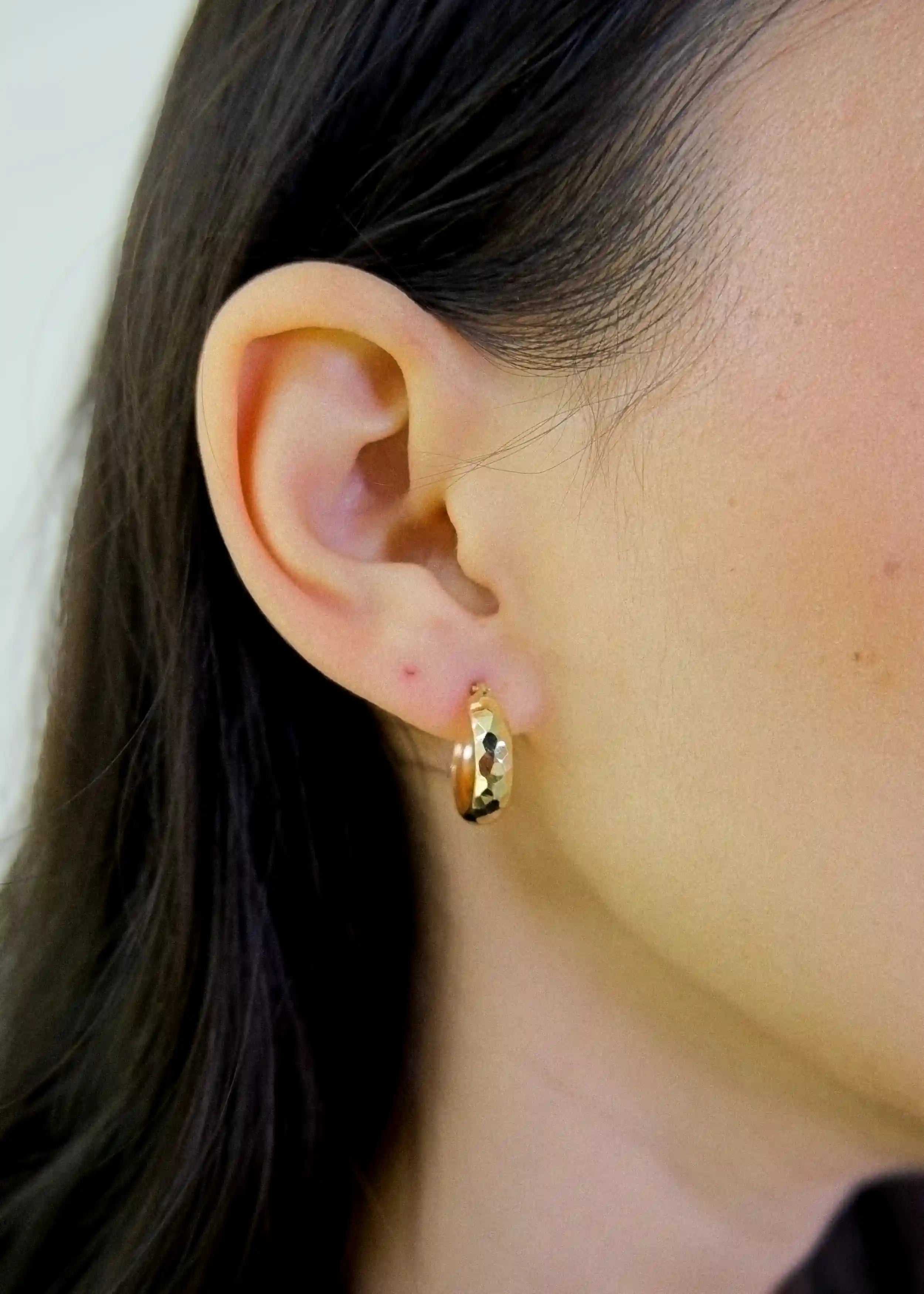 ein dame trägt Ohrringe Creolen mit Muster – 14 Karat (585er) Gelbgold Huggie Ohrringe mit Klappverschluss- Anadolu Juweliere