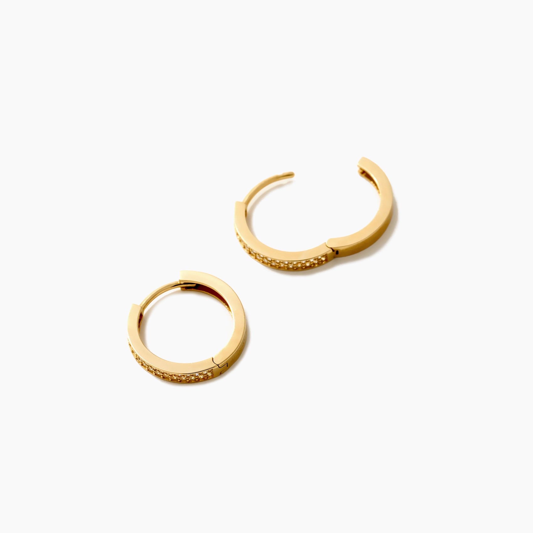 Vela 14K Gold-Huggie-Ohrringe mit Pave-Zirkonia-Besatz. 15,7 mm breit, Scharnier-Verschluss, hypoallergen.